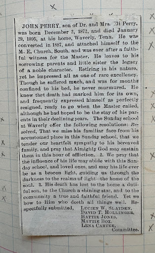 Newspaper obituary clipping preserved inside the church record book.
