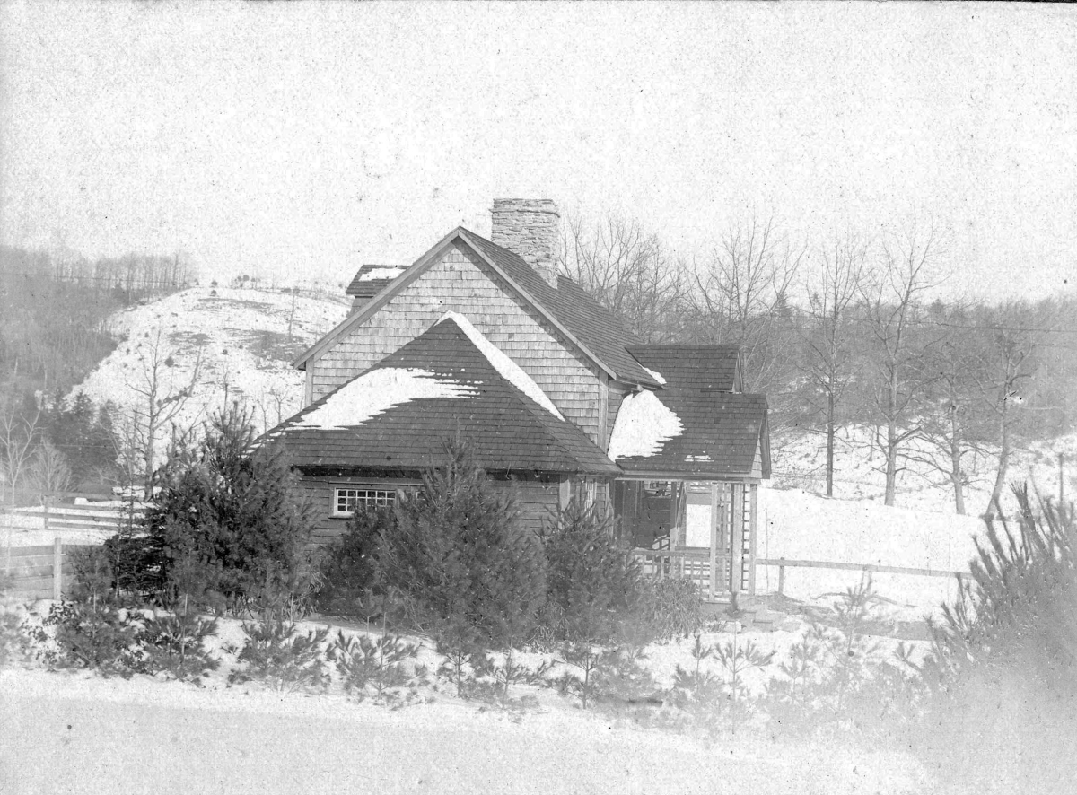 A view of a house or house-type building, set amid a snowy scene in a mountainous landscape.