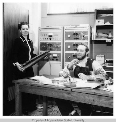 1972 photo of Charlotte Ross with man seated at microphone