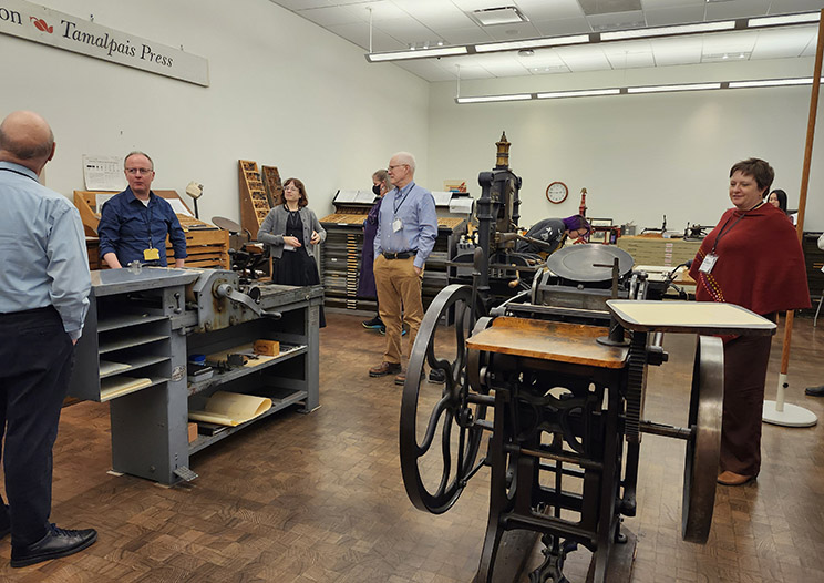 Seminar students look at several hand presses