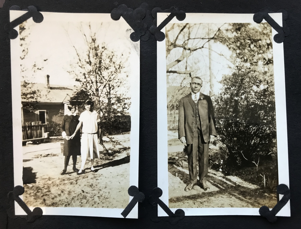 Page of a scrapbook with two portraits: one shows two young women standing in front of a house and a tree, lightly touching hands; the other depicts a young man standing outdoors wearing a formal dress suit.