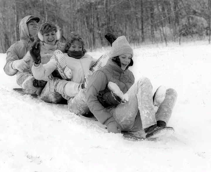 Students sledding on cafeteria trays, 1984