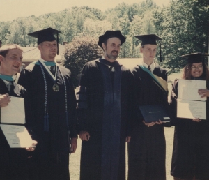Dr. Stephen Fisher, Ph.D., center, stand in doctoral academic robes with four of his students, wearing academic robes and regalia